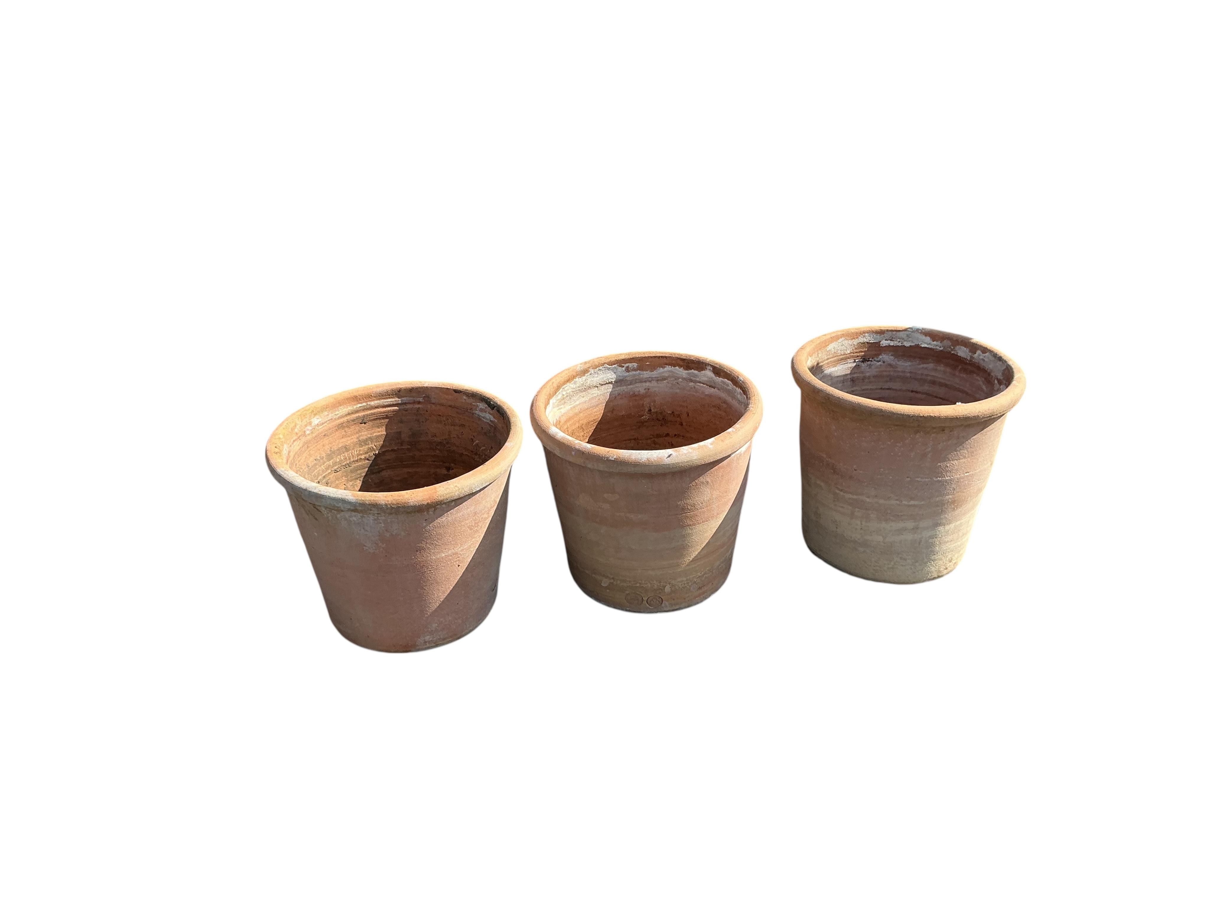 A set of three circular terracotta garden planters, diameter 41cm, height 38cm